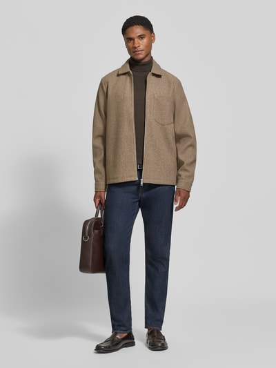 Männermodel trägt Jacke mit Brusttasche und Kentkragen Modell 'ROLFSTED' von Casual Friday in Beige, gerader Schnitt, Ganzkörperansicht von vorne.