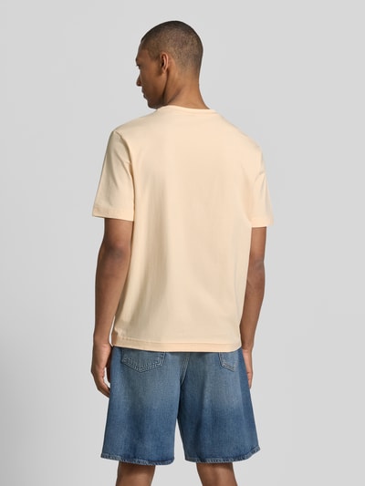Männermodel trägt Regular Fit T-Shirt aus Baumwoll-Mix Modell 'TCHUP' von BOSS für BOSS Orange in Beige, glatte Struktur, Ganzkörperansicht Rückansicht.