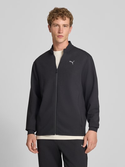 Männermodel trägt schwarze Sweatjacke mit Stehkragen und Reißverschluss Modell 'CLOUDSPUN' von PUMA PERFORMANCE, Material-Mix, Logo, Ganzkörperansicht von vorne