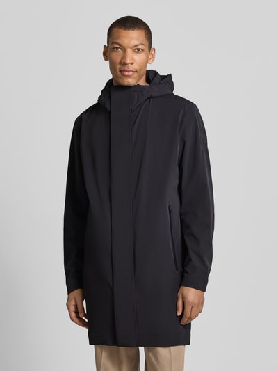 Männermodel trägt Regular Fit Funktionsmantel aus wasserabweisendem Material von Strellson in Schwarz, Kapuze, Reißverschlusstaschen, Ganzkörperansicht von vorne
