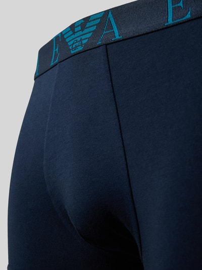 Männermodel trägt Trunks im 3er-Pack mit elastischem Logo-Bund von Emporio Armani, dunkelblauer Baumwoll-Mix mit Stretch-Anteil, Nahaufnahme Oberkörper.