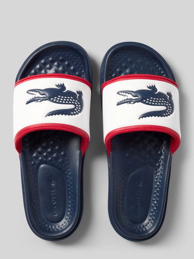Produktfoto, Badeschuhe mit Logo-Print Modell 'SERVE SLIDE 1.0' von Lacoste, Optik: Mehrfarbig, Schuhspitze: Rund, Absatzform: Flach, Applikation: Logo-Schriftzug, Verschluss: Schlupf/offen, Sohle: Strukturiert
