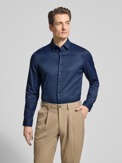 Männermodel trägt Slim Fit Business-Hemd mit Kentkragen von Jake*s, marineblau, aus Material-Mix mit Stretch-Anteil, Knopfleiste, Ganzkörperansicht von vorne.