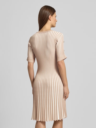 Frauenmodel trägt Minikleid mit gerippten Abschlüssen von LIU JO SPORT in Beige mit vertikalem Streifenmuster, tailliert, Rückenansicht Ganzkörperansicht. Viskose-Mix, V-Ausschnitt, Label-Print, Länge 87 cm, Brustweite 35 cm, Ärmellänge 25 cm.