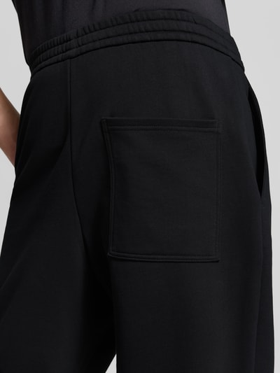 Männermodel trägt Sweatpants mit elastischem Bund von Moose Knuckles, Baumwollmischung in Schwarz, Detailaufnahme Rückansicht.