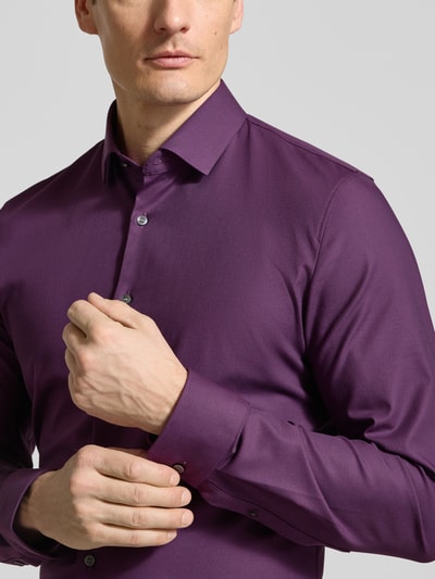 Männermodel trägt Super Slim Fit Business-Hemd Modern Kent Uni Twill von OLYMP No. Six in Lila, elastischer Baumwoll-Mix, Nahaufnahme Oberkörper.