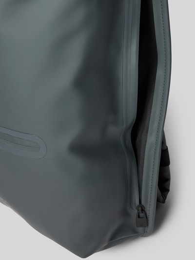 Produktfoto, grauer Rucksack mit Karabinerverschluss Modell 'Rolltop' von Rains, wasserabweisendes Material, Detailaufnahme Reißverschluss