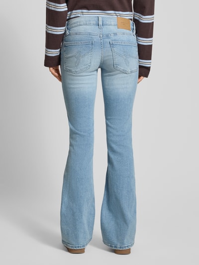 Frauenmodel trägt Flared Fit Jeans im Used-Look von Gina Tricot aus elastischem Baumwoll-Mix mit 5-Pocket-Design, Bundweite 39 cm, Innenbeinlänge 84 cm, Ganzkörperansicht Rückansicht.