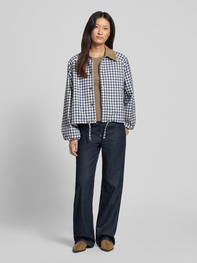 Kobiece modelka nosi bluzon Regular Fit Blouson mit Viskose-Anteil model 'OVINGHAM' od Barbour, granatowo-biała krata, jasnobrązowe detale, tekstura gładka, damska bomberka/bluzon, pełny widok od przodu.