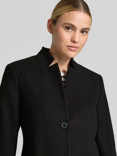 Frauenmodel trägt Mantel mit Viskose-Anteil von COMMA in Schwarz, feine Textur, Knopfverschluss, Nahaufnahme Oberkörper, taillierte Passform.
