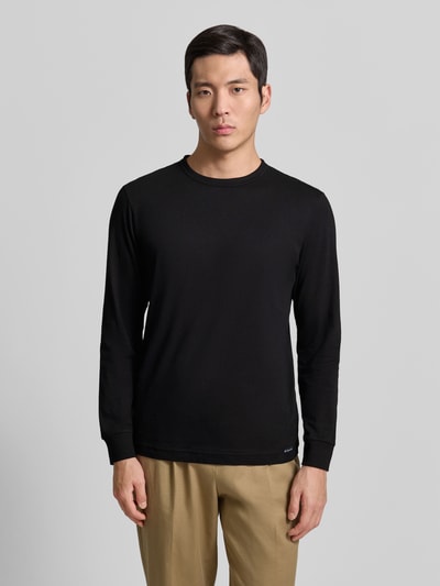 Männermodel trägt Regular Fit Langarmshirt aus reiner Baumwolle von Tom Tailor in Schwarz, unifarbenes Jersey, Rundhals, Ganzkörperansicht von vorne.