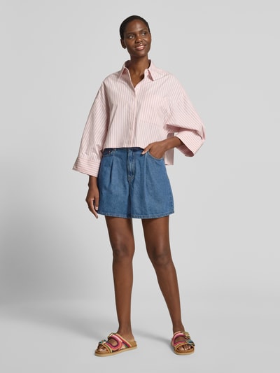 Frauenmodel trägt Jeansshorts mit Eingrifftaschen Modell 'GEMMA' von YAS in Blau, Reine Baumwolle, Regular-Fit, Ganzkörperansicht von vorne, Bundweite bei Größe 36: 37 cm, Innenbeinlänge bei Größe 36: 41 cm.