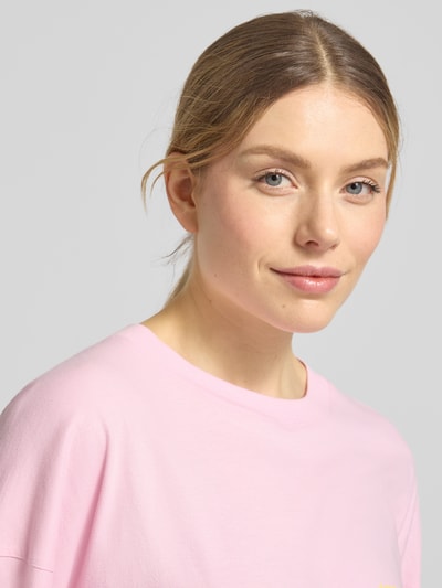 Frauenmodel trägt Longsleeve mit Label-Print Modell 'GIXY' von American Vintage in zartem Rosa, Reine Baumwolle, Relaxed-Fit, Rundhalsausschnitt, Nahaufnahme Oberkörper. Rückenlänge bei Größe XS/S: 64 cm.