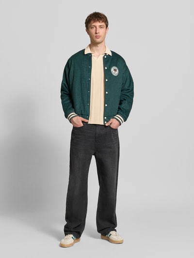 Männermodel trägt Slim Fit Poloshirt in Strick-Optik Modell 'Baron' von Blend, cremefarben, Baumwolle, Polokragen, Ganzkörperansicht von vorne.