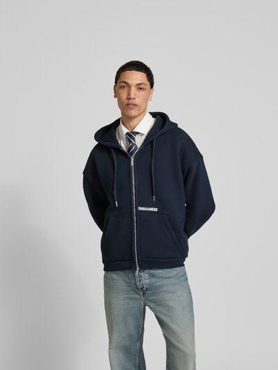 Männermodel trägt Oversized Sweatjacke aus Baumwoll-Mix von Dsquared2 in Dunkelblau mit Zweiwege-Reißverschluss, Känguru-Tasche, Kapuze mit Tunnelzug, Baumwoll-Elasthan-Mix, Ganzkörperansicht von vorne.