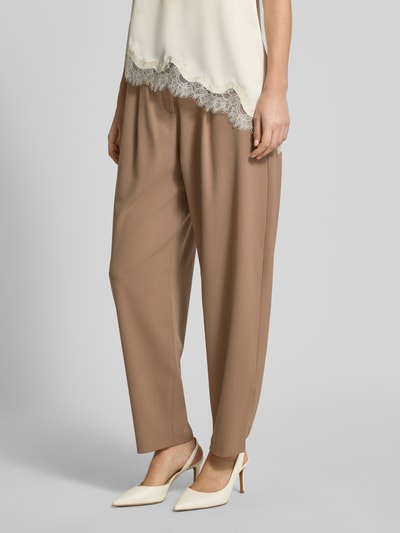 Frauenmodel trägt Wide Fit Stoffhose mit Schurwoll-Anteil Modell 'Megan' von Brax in Beige, elastischer Material-Mix, gelegte Falten, eingefasste Beinabschlüsse, Bundweite 40 cm, Innenbeinlänge 68 cm, Nahaufnahme Unterkörperansicht.