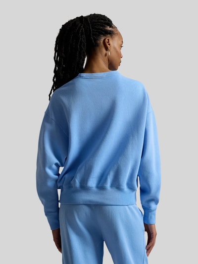 Vrouwenmodel draagt Regular Fit Sweatshirt aus Baumwoll-Mix van Polo Ralph Lauren in effen lichtblauw katoenmix, geribde boorden, logo-details, langemouw, crew neck, sweatmateriaal, volledige lichaamsopname achterkant.