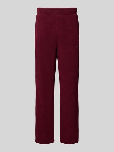 Produktfoto, Wide Fit Sweatpants mit Label-Detail Modell 'Mezzano' von PEGADOR in Dunkelrot, elastisches Material, gerade Form, strukturierte Oberfläche, Eingrifftaschen und elastischer Bund, Innenbeinlänge Größe M 78 cm.