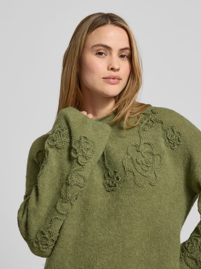 Frauenmodel trägt Strickpullover mit Stitchings Modell 'Miabelle Hope' von MSCH Copenhagen in Olivgrün, Material-Mix mit Alpaka, Nahaufnahme Oberkörper.