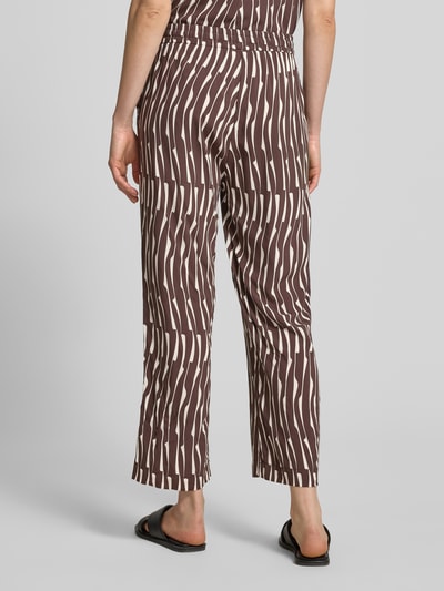Frauenmodel trägt Wide Leg Stoffhose aus Viskose Modell 'Marou bamboo' von OPUS mit braun-beigem Allover-Muster, Ganzkörperansicht Rückansicht.