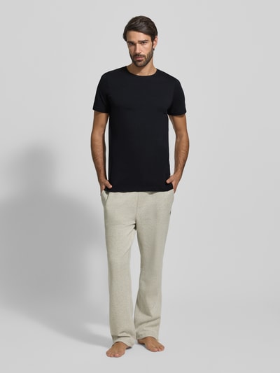 Męski model nosi T-Shirt mit Rundhalsausschnitt im 2er-Pack od MCNEAL, czarny, bawełna, krój slim fit, pełny przód, widok całej sylwetki.