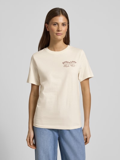 Vrouwenmodel draagt T-Shirt met Label-Print en Rundhalsausschnitt van Scotch & Soda, crème kleur, regular fit, voorkant, bio-katoen, ganzebodyvooraanzicht.