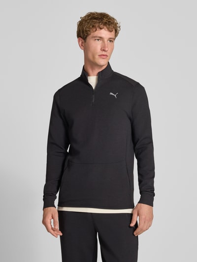 Męski model nosi bluzę Sweatshirt mit Label-Detail Modell 'CLOUDSPUN' od PUMA PERFORMANCE, elastyczna mieszanka materiałów z lyocellem, prosty krój, kołnierz zapinany, detal z logo, długość tyłu w rozmiarze M: 74 cm, długość rękawów w rozmiarze M: 74 cm, kolor czarny, gładka faktura, całkowity widok od przodu.