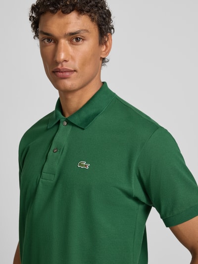 Männermodel trägt Poloshirt mit Label-Stitching Modell 'L.12.12 CORE' von LACOSTE, reine Baumwolle, Unifarbenes-Design, Nahaufnahme Oberkörper.