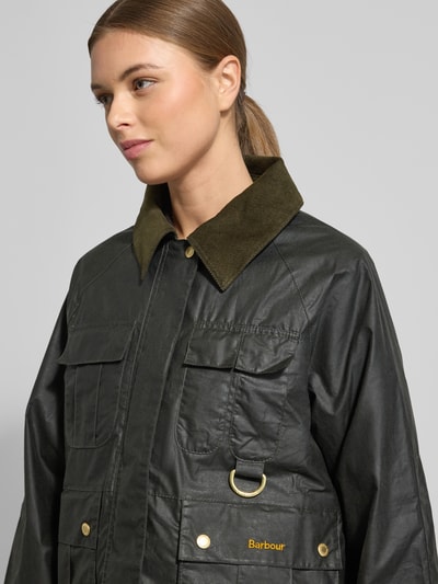 Kobiece model prezentuje Regular Fit Funktionsjacke aus reiner Baumwolle Modell 'LIZA' von Barbour, krój regular fit, efekt: jednolity kolor, stójka, odpinany kaptur, zapięcie na zatrzask z zamkiem błyskawicznym, długi rękaw z brzegiem, aplikacja z napisem z logo, metalowe akcenty, nakładane kieszenie, kieszenie boczne, kieszenie na piersi, kieszeń wewnętrzna, materiał: czysta bawełna, tekstura woskowana; zbliżenie na górną część ciała