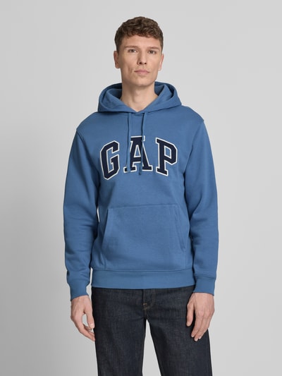 Mannelijk model draagt Hoodie mit Kängurutasche van GAP in blauw met grote logoprint, losse fit, katoenmix, kangoeroezak, vooraanzicht busteshot.
