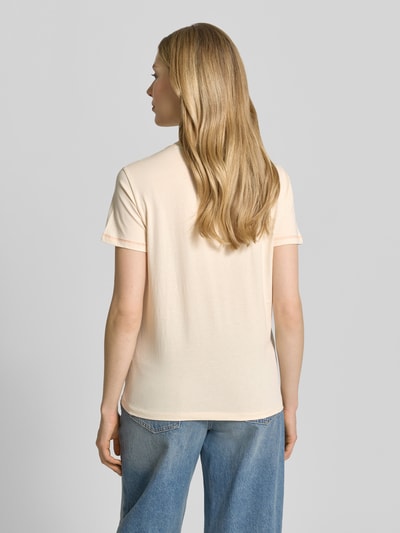 Modelka nosi damski t-shirt z motywem i okrągłym dekoltem od Jake*s Casual, wykonany z bawełny, krój regular fit, długość tyłu w rozmiarze S: 59 cm, jasny beż, gładka tekstura, całkowity widok z tyłu.