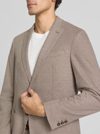 Männermodel trägt fein strukturiertes Slim Fit 2-Knopf-Sakko Modell 'Michel' von Pierre Cardin in Beige mit Reverskragen, Nahaufnahme Oberkörper. Herren 2-Knopf-Sakko, Material-Mix mit Viskose-Anteil, aufgesetzte Taschen.