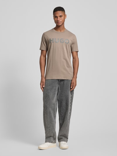 Männermodel trägt Relaxed Fit T-Shirt aus reiner Baumwolle Modell 'DULIVIO' von HUGO, Optik: Unifarben, Label-Schriftzug, Ganzkörperansicht von vorne.