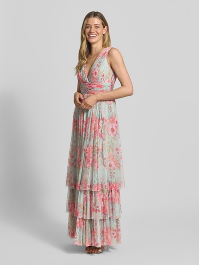Frauenmodel trägt Abendkleid mit Volantsaum und V-Ausschnitt von LACE & BEADS aus geblümtem Chiffon in A-Linie, Ganzkörperansicht von vorne.