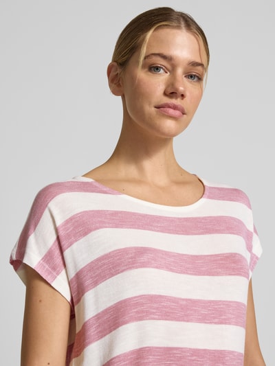 Frauenmodel trägt Boxy Fit T-Shirt aus Viskose-Mix Modell 'WIDE STRIPE' von Vero Moda mit Optik:Allover-Muster, Streifenmuster in Rosa und Weiß, Rundhals, Kurzarm, Feinstrick, asymmetrischer Rumpfabschluss, Nahaufnahme Oberkörper.