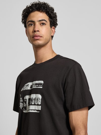 Männermodel trägt Regular Fit T-Shirt mit Logo-Print Modell 'icon' von G-Star Raw aus reiner Baumwolle, Nahaufnahme Oberkörper.