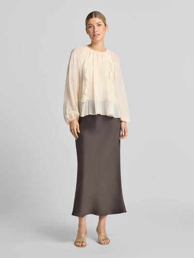 Frauenmodel trägt Bluse mit Raffungen von Christian Berg Woman Selection in Creme mit Volants, lockerer Passform, elastischen Abschlüssen, langärmelig, kombiniert mit langem Rock, Ganzkörperansicht von vorne.