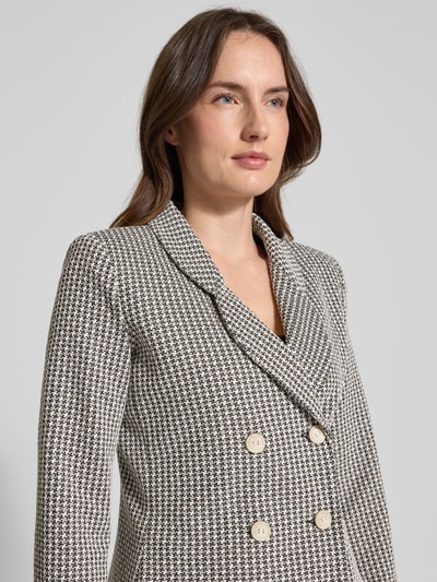 Frauenmodel trägt Slim Fit Blazer mit Reverskragen von Emporio Armani, Muster in Schwarz-Weiß, Doppelknopfleiste, Nahaufnahme Oberkörper.