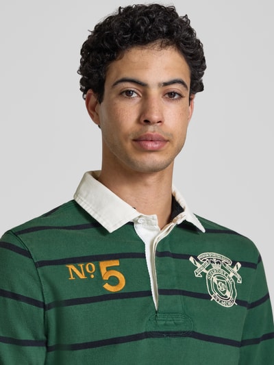 Männermodel trägt Regular Fit Rugby Shirt mit Logo- und Motiv-Stitching von Superdry, Reine Baumwolle, Polokragen, Nahaufnahme Oberkörper.