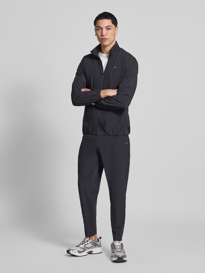 Männermodel trägt Trackpants mit elastischem Bund Modell 'EVARO' von Ellesse, Schwarz, Regular Fit, Material-Mix, Ganzkörperansicht von vorne.