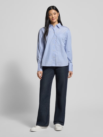 Frauenmodel trägt Regular Fit Hemdbluse aus reiner Baumwolle von Marc O'Polo mit blau-weißem Allover-Streifenmuster, Ganzkörperansicht von vorne.