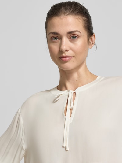 Kobiece modelka nosi bluzka aus Viskose mit Schlüsselloch-Ausschnitt von Emily Van den Bergh, kolor kremowy, długość tyłu w rozmiarze 36: 53 cm, długość rękawów w rozmiarze 36: 64 cm, krój loose fit, wiązanie przy wycięciu w kształcie łezki, elastyczne wykończenia, zdjęcie: zbliżenie górna część ciała.