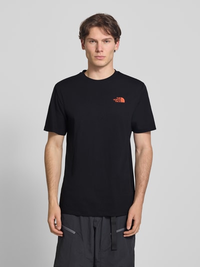 Männermodel trägt T-Shirt mit Logo und Rundhalsausschnitt van The North Face van katoenmix in zwart, regular fit, ruglengte maat M 72 cm, Ganzkörperansicht van voren