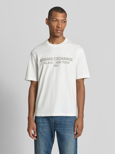 Männermodel trägt T-Shirt mit Label-Print und Rundhalsausschnitt von Armani Exchange in Weiß, reine Baumwolle, Relaxed Fit, Nahaufnahme Oberkörper.