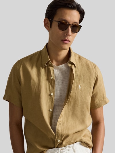 Mannenmodel draagt Regular Fit Leinenhemd mit Button-Down-Kragen van Polo Ralph Lauren in effen kleuren, pure linnen, logo-stitching, doorlopende knoopsluiting, korte mouw, licht afgeronde rompzoom, look: effen, nahaufnahme bovenlichaam.