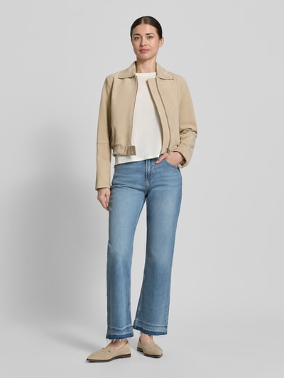Frauenmodel trägt Cropped Jeans aus Baumwoll-Mix Modell 'C-SOFT KICK FLARE1.0' von BOSS Orange in Denim-Optik mit Flared-Silhouette, Label-Patch, Nieten, Gürtelschlaufen, Knopf und verdecktem Reißverschluss, Fransen am Beinabschluss, 5-Pocket-Design; Ganzkörperansicht von vorne.