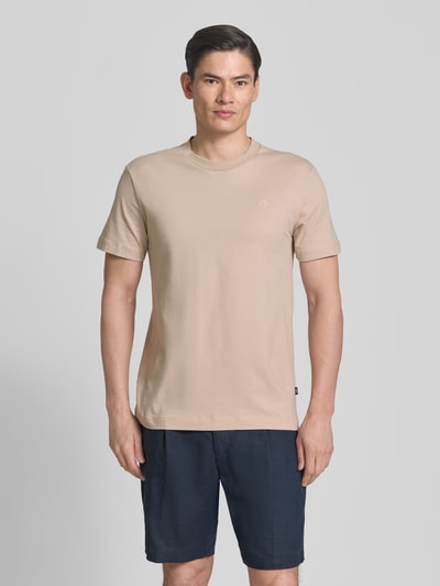 Männermodel trägt T-Shirt mit Rundhalsausschnitt Modell 'Carlonito' von JOOP! Collection aus beigem Baumwoll-Mix, Straight Fit, Ganzkörperansicht von vorne.
