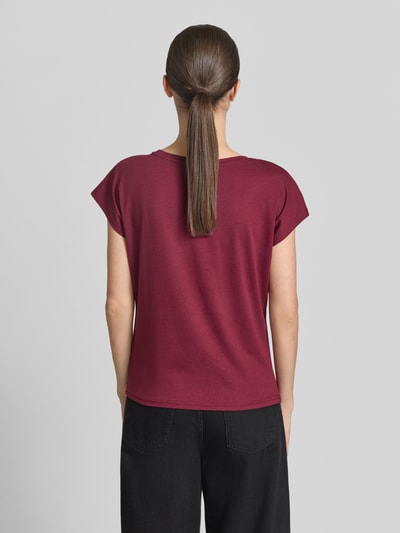 Modelka nosi T-Shirt mit Motiv-Print und Rundhalsausschnitt von Christian Berg Woman, mieszanka bawełny i wiskozy, krój regular fit, długość pleców w rozmiarze S: 55 cm, kolor bordowy, gładka tekstura, widok całej sylwetki z tyłu.