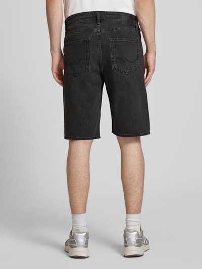 Mannenmodel draagt Baggy Fit korte jeans van puur katoen, model 'ALEX' met steekzakken van Jack & Jones, geheel van achteren. Context: heren korte jeans van Jack & Jones, puur katoen, baggy fit, model 'ALEX', steekzakken, bandwijdte maat M: 42 cm, binnenbeenlengte maat M: 26 cm.