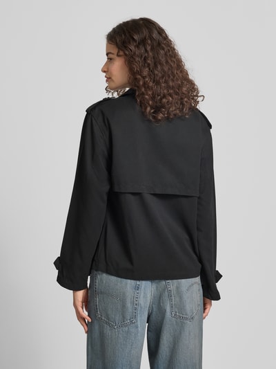 Frauenmodel trägt Regular Fit Trenchcoat-Jacke mit Reverskragen Modell 'HANNAH' von Only in Schwarz, unifarben, Rückenpasse, Ganzkörperansicht Rückansicht.